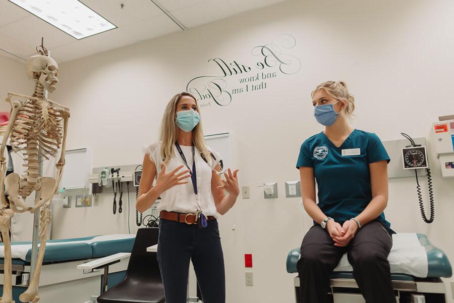 a faculty member teaching a health class in a nursing classroom